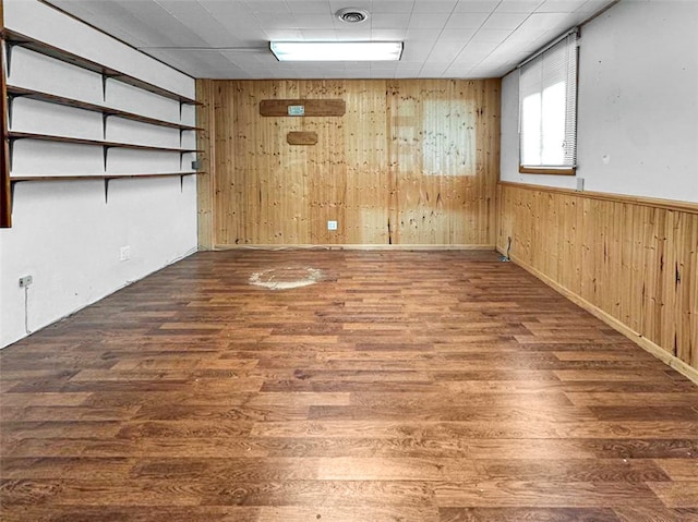 basement with wood walls and dark hardwood / wood-style flooring