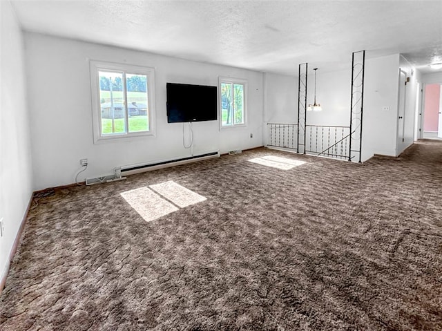 unfurnished living room with carpet floors, a textured ceiling, baseboard heating, and a healthy amount of sunlight