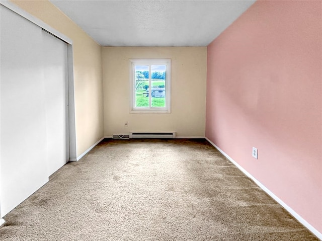 carpeted spare room with a baseboard radiator