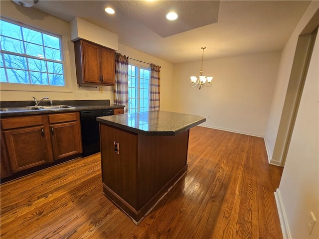 kitchen with dark wood-type flooring, sink, a center island, black dishwasher, and pendant lighting