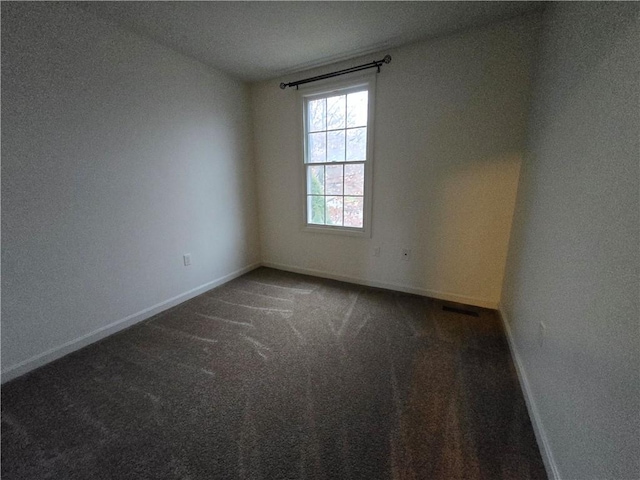 unfurnished room with dark colored carpet