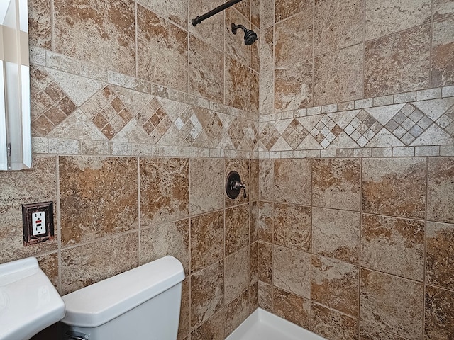 bathroom with tiled shower and toilet