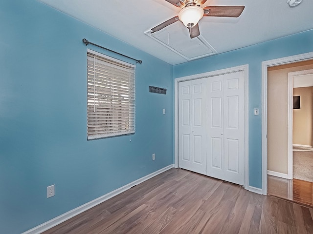 unfurnished bedroom with ceiling fan, a closet, and wood-type flooring