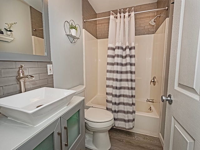 full bathroom with vanity, backsplash, hardwood / wood-style flooring, shower / bathtub combination with curtain, and toilet