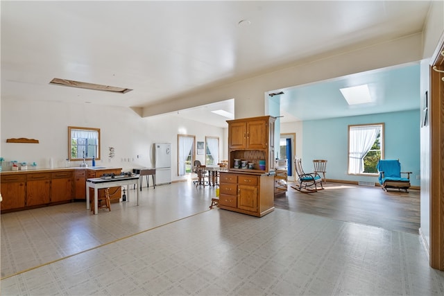 kitchen featuring kitchen peninsula, white refrigerator, sink, and light hardwood / wood-style floors