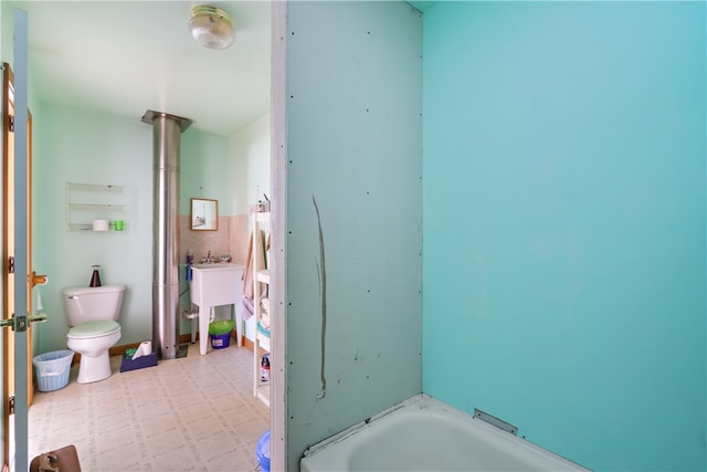 bathroom featuring a tub and toilet