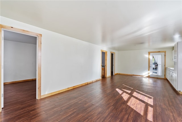 empty room with dark hardwood / wood-style flooring