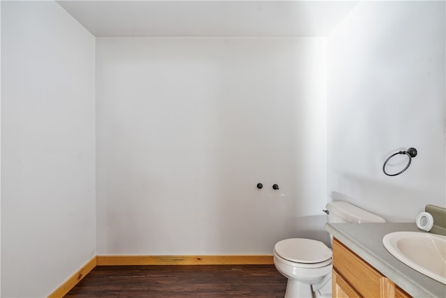 bathroom with vanity, toilet, and hardwood / wood-style flooring