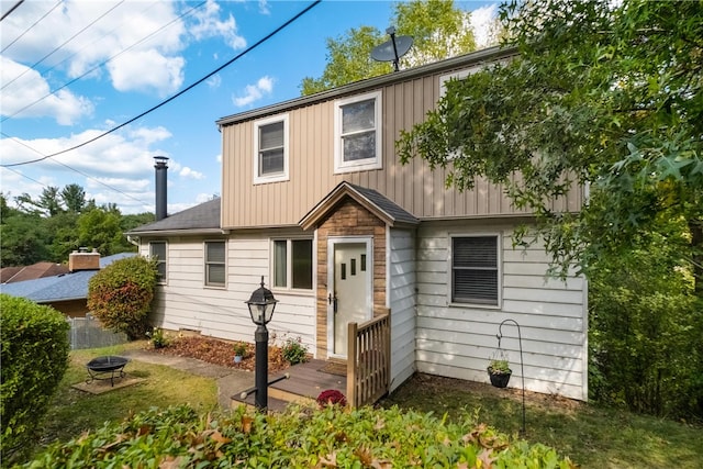 back of house with a fire pit and a wooden deck