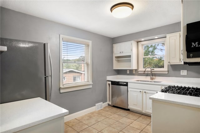 kitchen featuring appliances with stainless steel finishes, a healthy amount of sunlight, sink, and white cabinets