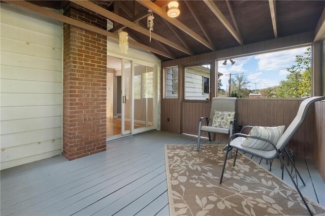 sunroom / solarium featuring plenty of natural light and vaulted ceiling with beams