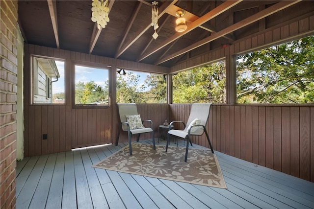 sunroom / solarium featuring vaulted ceiling with beams