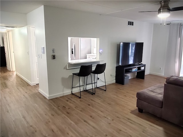 living room with ceiling fan and light hardwood / wood-style flooring