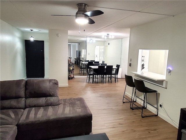 living room with ceiling fan and light hardwood / wood-style flooring