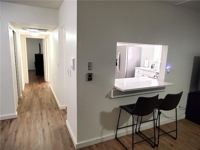 hallway featuring baseboards and wood finished floors