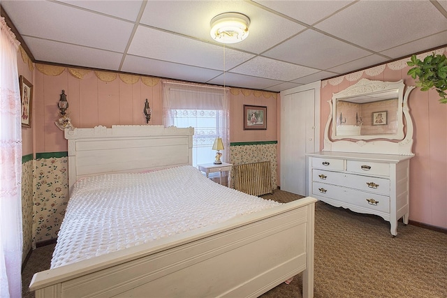 carpeted bedroom featuring a drop ceiling