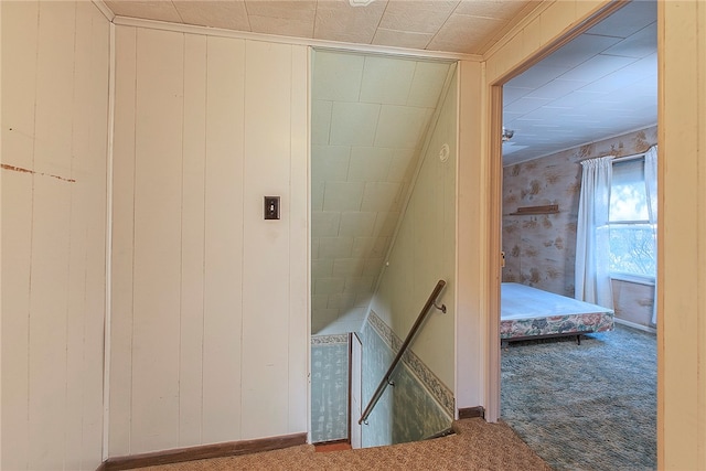 staircase with carpet and wood walls