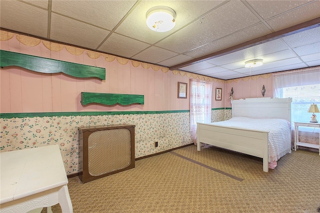 carpeted bedroom with a paneled ceiling and multiple windows