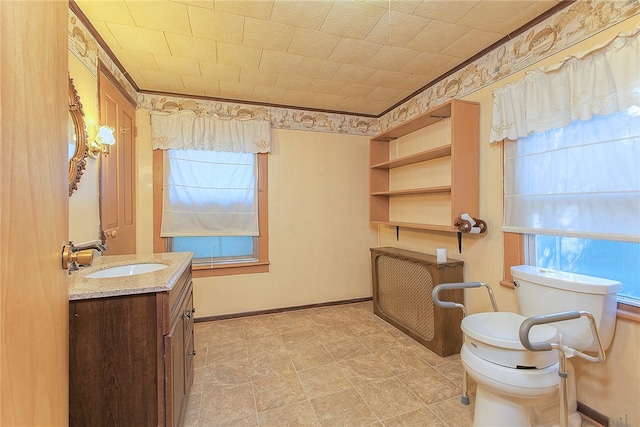 bathroom with vanity, toilet, and radiator