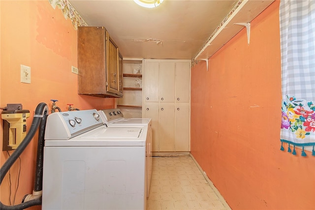 washroom featuring washing machine and dryer and cabinets