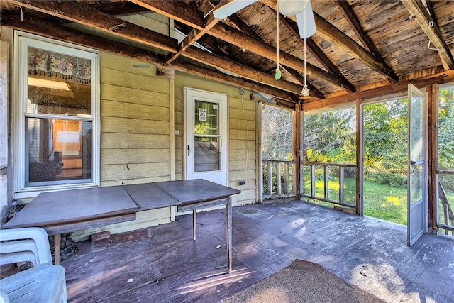 unfurnished sunroom featuring ceiling fan and lofted ceiling with beams