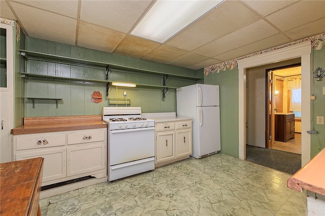 kitchen with wood counters, white appliances, white cabinets, and a drop ceiling