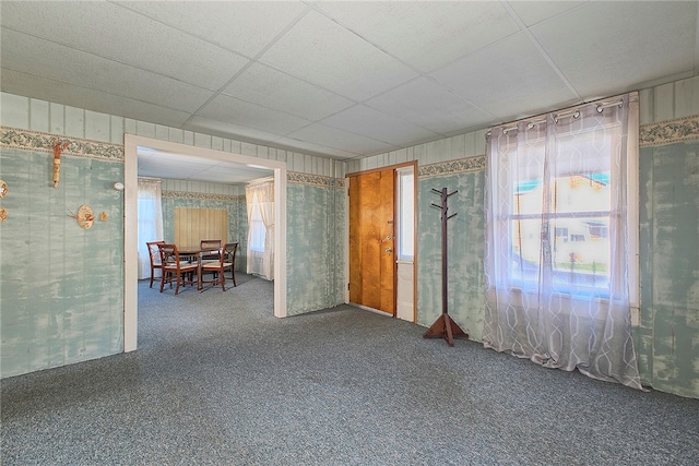 spare room featuring carpet flooring and a drop ceiling