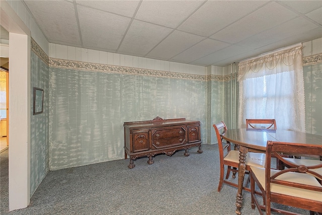 carpeted dining space featuring a drop ceiling