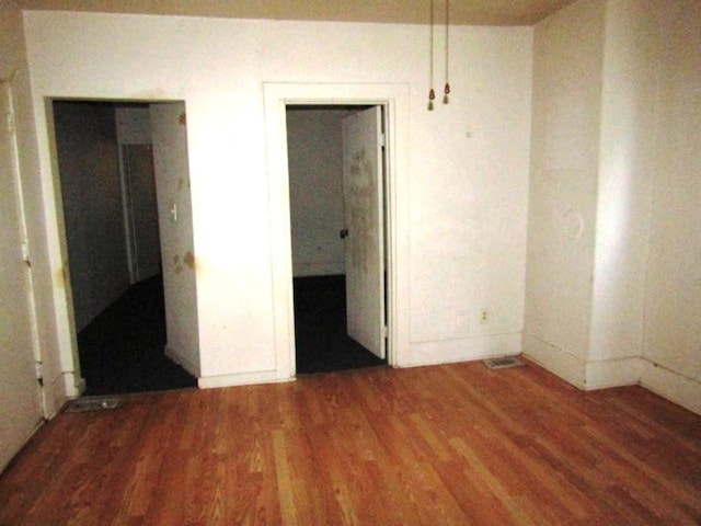 unfurnished bedroom with baseboards and wood finished floors