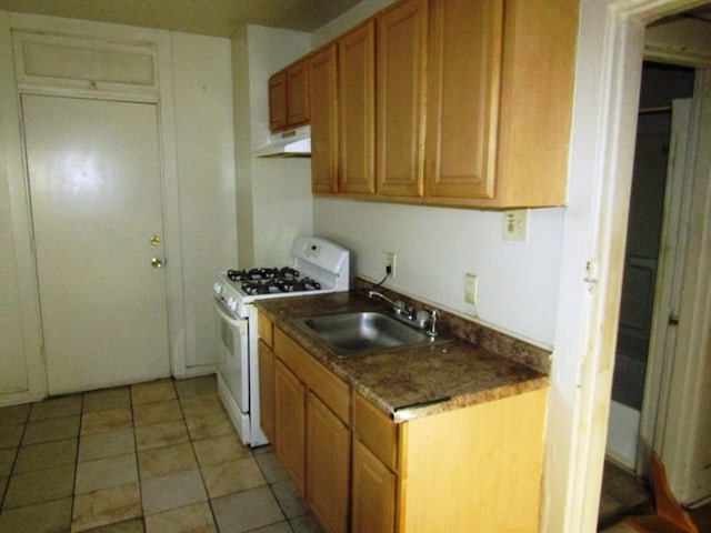 kitchen featuring light tile patterned floors, sink, and white gas range oven