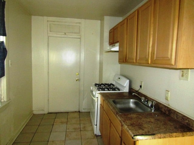 kitchen with white gas stove, sink, and light tile patterned floors