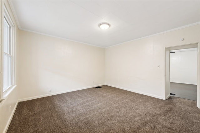 spare room with dark colored carpet and ornamental molding