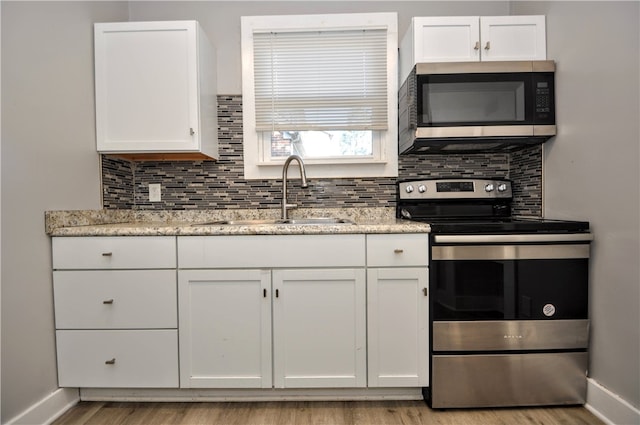 kitchen with tasteful backsplash, sink, stainless steel appliances, and white cabinets