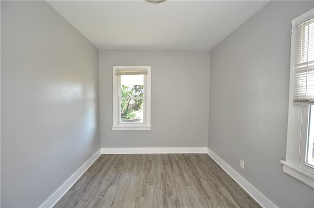 unfurnished room featuring light wood-type flooring and plenty of natural light