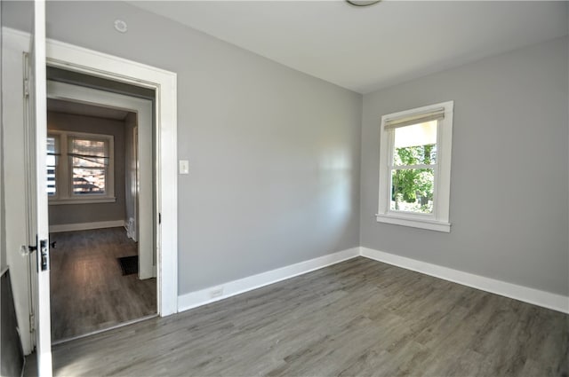 unfurnished room with dark wood-type flooring