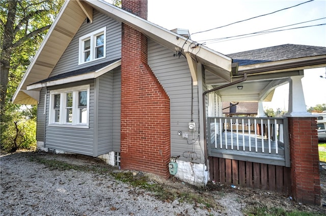 view of side of property featuring covered porch