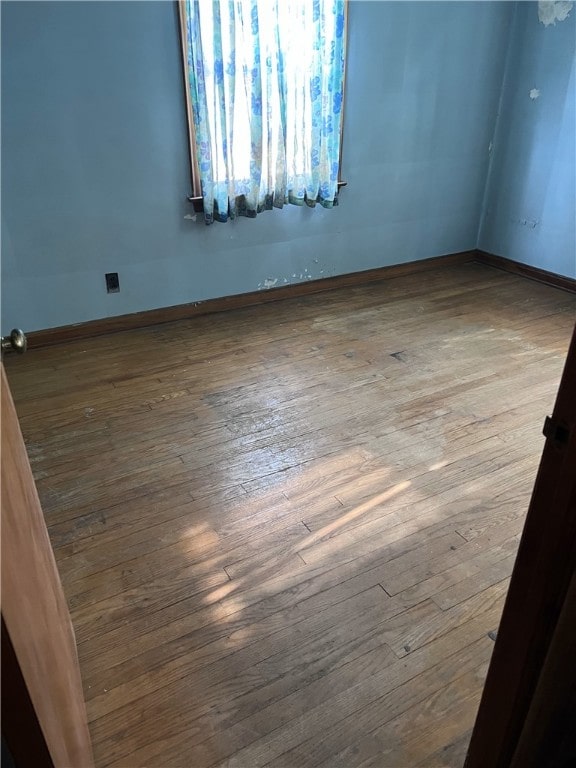 unfurnished room featuring hardwood / wood-style flooring