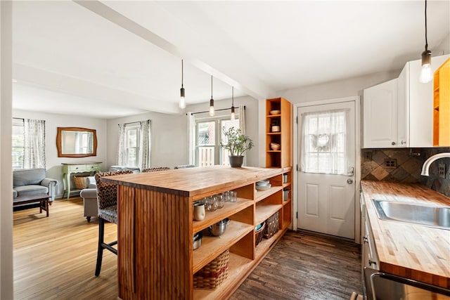 kitchen with butcher block counters, decorative light fixtures, and a healthy amount of sunlight