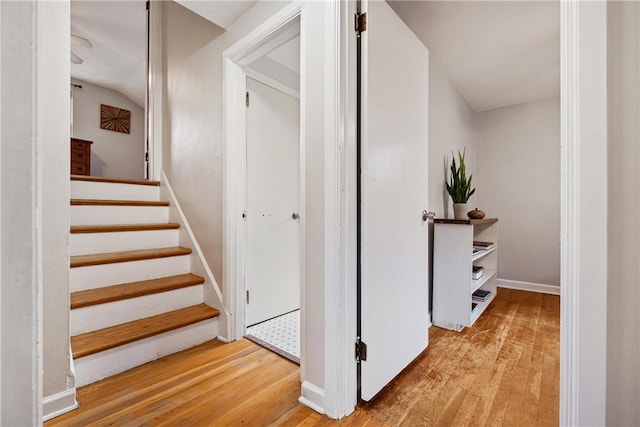 stairs with lofted ceiling and wood-type flooring