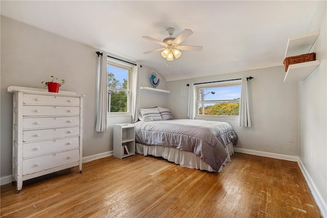 bedroom featuring hardwood / wood-style floors, lofted ceiling, and ceiling fan