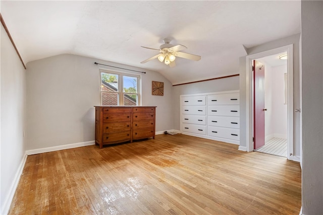 unfurnished bedroom featuring light wood-type flooring, ceiling fan, and vaulted ceiling