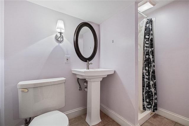 bathroom featuring tile patterned flooring, a shower with shower curtain, and toilet