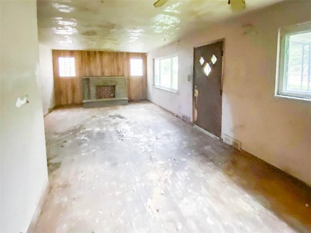 unfurnished living room featuring a fireplace with raised hearth and plenty of natural light