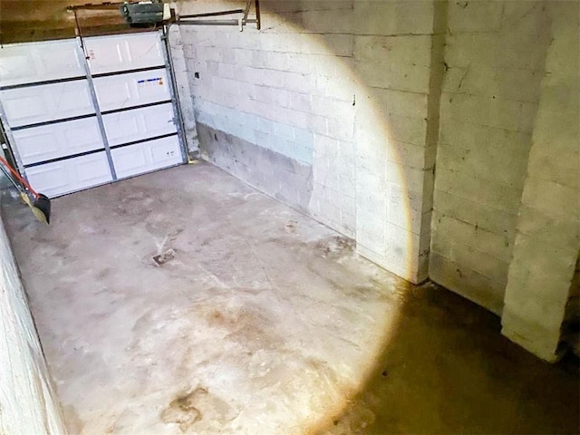interior space featuring concrete block wall and a garage door opener