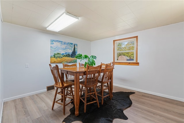 dining space with light hardwood / wood-style floors