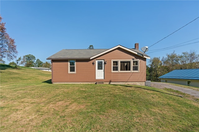 rear view of property featuring a yard