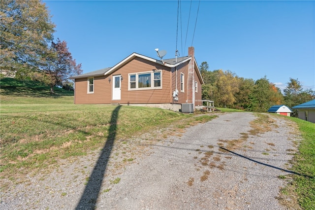 view of side of property with cooling unit and a yard