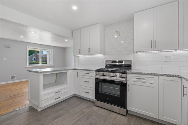 kitchen with white cabinets, stainless steel gas range, and light hardwood / wood-style floors