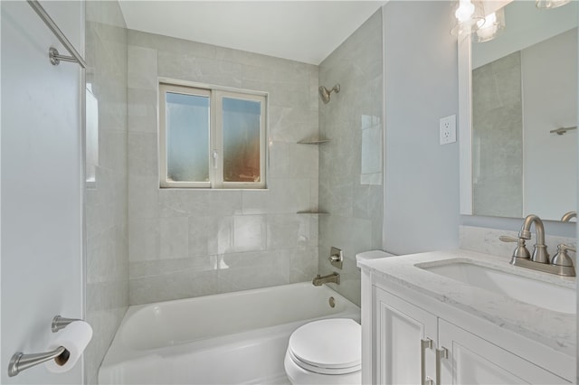 full bathroom featuring tiled shower / bath, vanity, and toilet