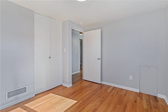 unfurnished bedroom with a closet and light hardwood / wood-style floors